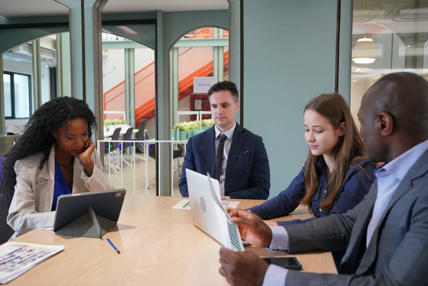 若いビジネスマンや同僚の会議でノートパソコンやタッチパッドで文書を議論のイメージ - 写真・画像