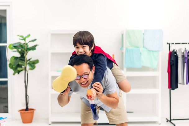 Ritratto di godere felice amore asiatico famiglia padre portando piccolo asiatico ragazzo figlio sorridente giocare supereroe e avendo divertimento momenti buon tempo su letto a casa - Foto, immagini