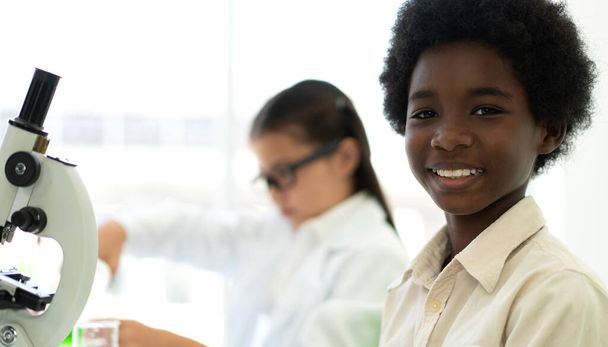 Skupina dospívajících se učí a studuje chemický experiment a drží zkumavku v ruce v experimentální laboratorní třídě na stole ve školě.Vzdělávací koncepce - Fotografie, Obrázek