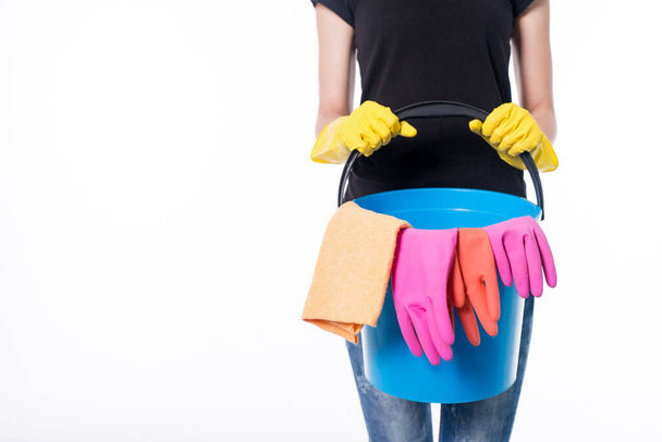 Happy young woman holding a mop and a bucket filled with cleaning products isolated on white background. - Фото, зображення