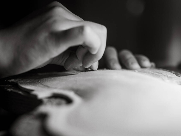 artisan working on raw wood violin plate with finger plane on the bench - Φωτογραφία, εικόνα