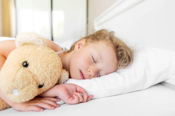 The child sleeps peacefully in his bed. - Valokuva, kuva