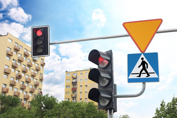 Different road signs and traffic lights on city street - Фото, зображення