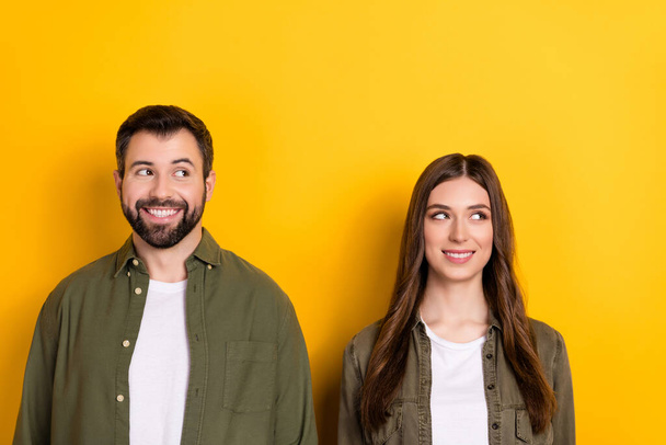 Photo of cheerful nice partners beaming smile look interested empty space isolated on yellow color background. - Foto, Imagen