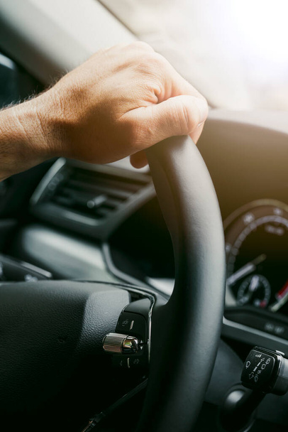 Close up shot of male hands on a car's steering wheel. - Photo, Image