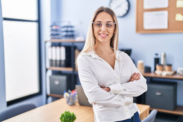 Young woman business worker standing with arms crossed gesture at office - Photo, Image