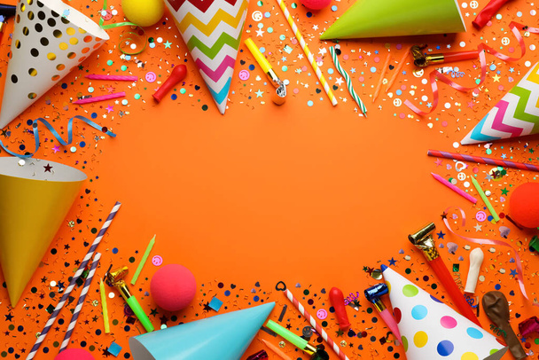 Frame of festive items on orange background, flat lay with space for text. Surprise party concept - Fotó, kép