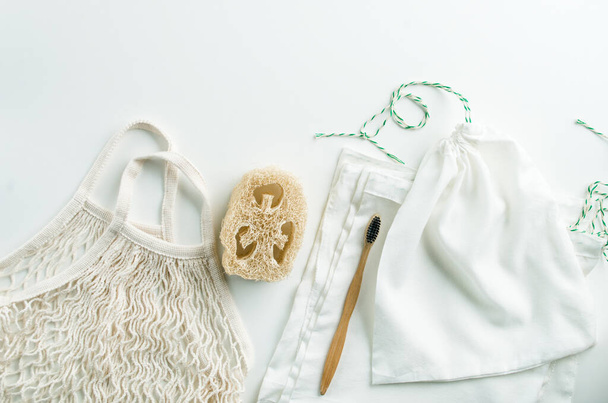 白い背景にメッシュバッグ再利用可能なパッケージ、ルファと竹の歯ブラシのゼロ廃棄物セット。高品質の写真 - 写真・画像