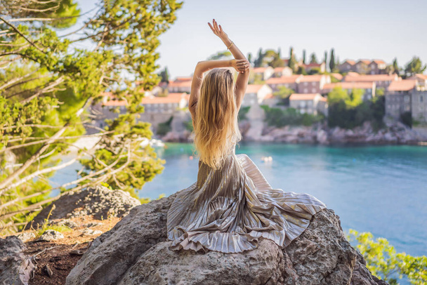 Woman tourist on background of beautiful view of the island of St. Stephen, Sveti Stefan on the Budva Riviera, Budva, Montenegro. Travel to Montenegro concept. - Fotoğraf, Görsel