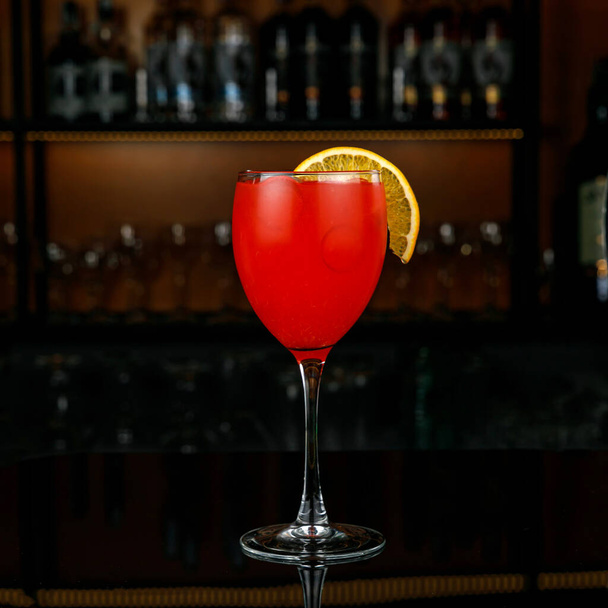 cocktail with red and orange in a glass on a bar counter - Fotografie, Obrázek