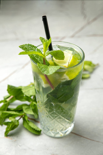 glass of fresh lemonade with mint and rosemary on a white background - Fotó, kép
