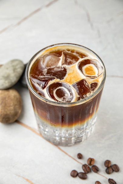 glass of cold coffee with ice cubes on wooden background - Φωτογραφία, εικόνα