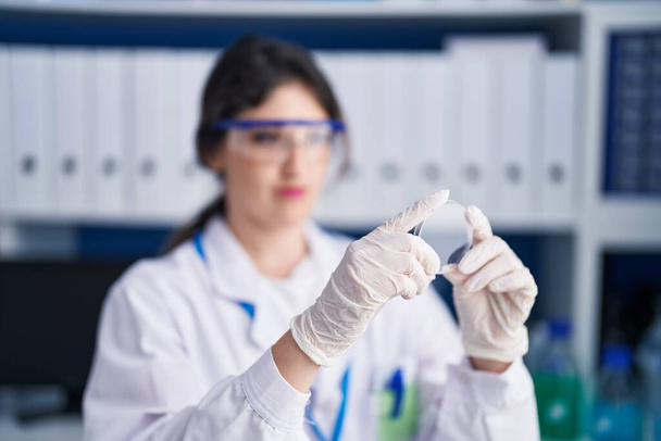 Молода іспаномовна жінка вчений дивиться зразок в лабораторії
 - Фото, зображення