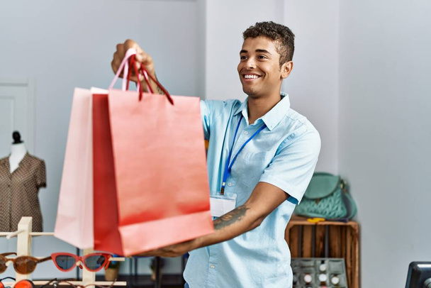 Fiatal spanyol férfi, bolti asszisztensként dolgozik a kiskereskedelmi üzletben. - Fotó, kép