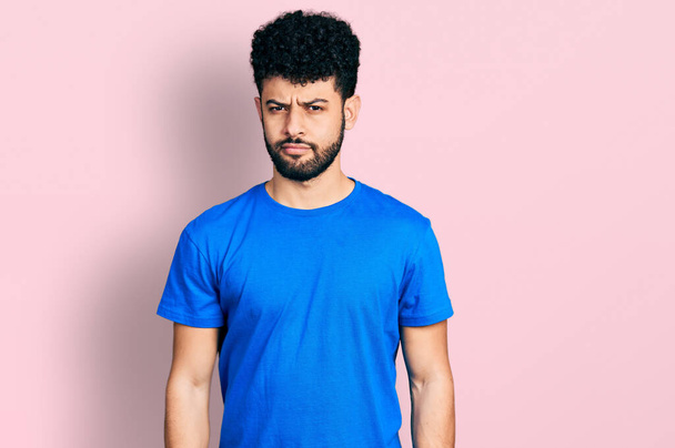 Hombre árabe joven con barba con camiseta azul casual relajado con expresión seria en la cara. simple y natural mirando a la cámara.  - Foto, Imagen