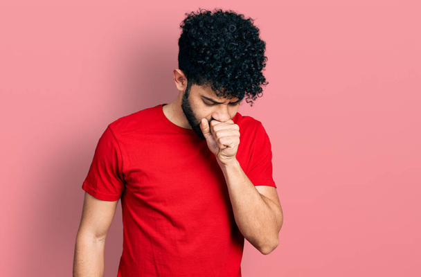 Homem árabe jovem com barba vestindo casual camiseta vermelha sentindo-se mal e tosse como sintoma de frio ou bronquite. conceito de cuidados de saúde.  - Foto, Imagem