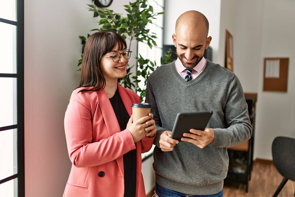 Dois empresários hispânicos trabalhando usando laptop e bebendo café no escritório. - Foto, Imagem