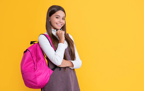 positive child with school backpack on yellow background. - Valokuva, kuva