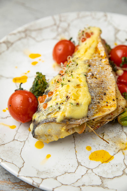 baked sea bream fish with tomatoes, peppers, sauce and broccoli - Foto, Imagem