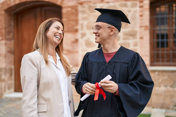 Erkek ve kadın anne ve oğul üniversitede yüksek lisans yapmak için bir arada duruyorlar. - Fotoğraf, Görsel