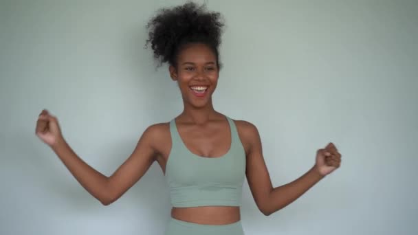 幸せな若いアフリカ系アメリカ人女性が運動をしている - 映像、動画