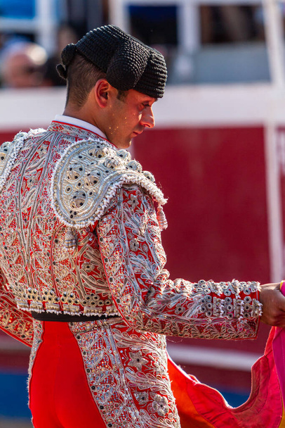 a Spanish bullfighter dressed with typical hat practices with his capote moments before the bullfight - Photo, Image