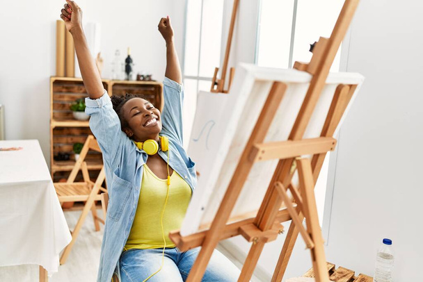 Молодая африканская художница-американка улыбается счастливому рисунку в художественной студии. - Фото, изображение