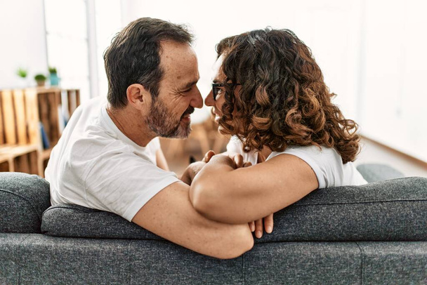 Middle age hispanic couple smiling happy sitting on the sofa at home. - Fotó, kép