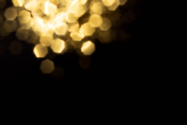 Golden blurred bokeh lights on black background. Glitter sparkle stars for celebrate. Overlay for your design - Photo, image