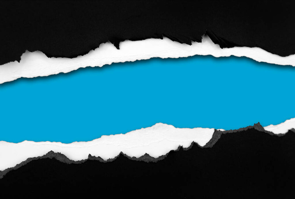 Papel negro rasgado sobre fondo azul, espacio para copia - Foto, imagen