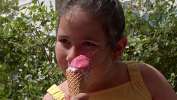 Маленька дівчинка дивиться на камеру під час їжі морозива Кадри
. - Кадри, відео