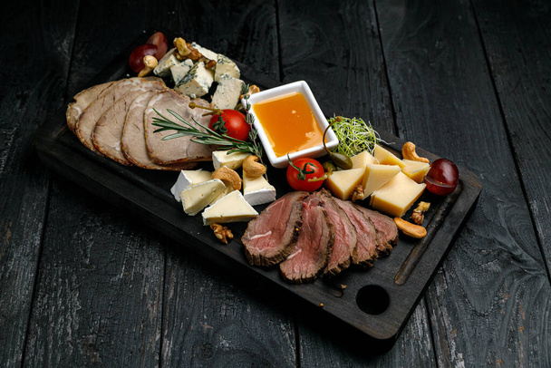 grilled meat with vegetables and cheese on a wooden board - Foto, Imagen