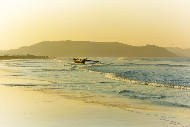 Amanecer en la costa de Goa. Barco de pesca en las olas listo para sai
 - Foto, Imagen