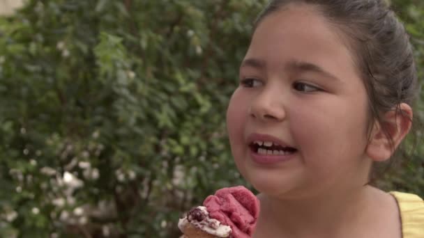 Klein meisje glimlachen op zoek naar camera terwijl het eten van ijs Beelden. - Video