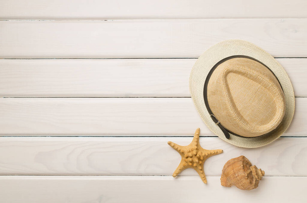 Wicker hat and seashells on wooden background, top view. - Photo, Image