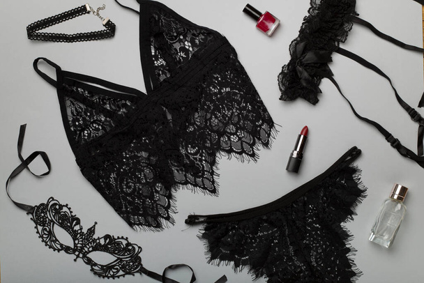 Set of black sexy lace lingerie with accessories on color background, top view. - Фото, зображення
