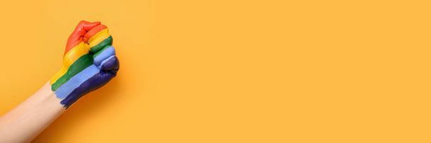 Punho feminino pintado em cores de bandeira LGBT em fundo laranja com espaço para texto - Foto, Imagem