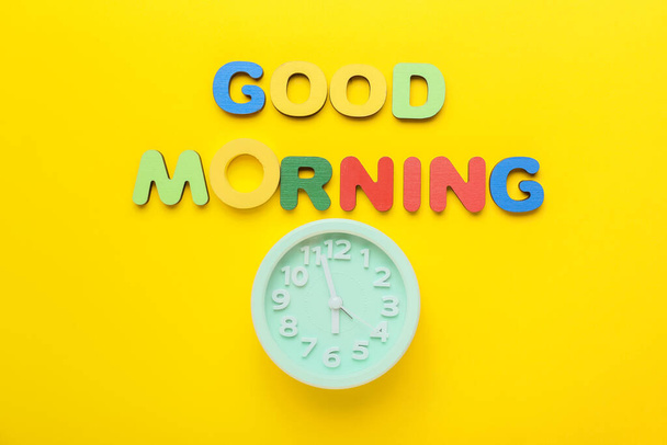 テキスト色の文字と黄色の背景に目覚まし時計で作られた良い朝 - 写真・画像