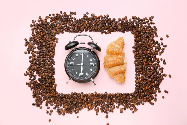 コーヒー豆、クロワッサンとピンクの背景に目覚まし時計と組成 - 写真・画像