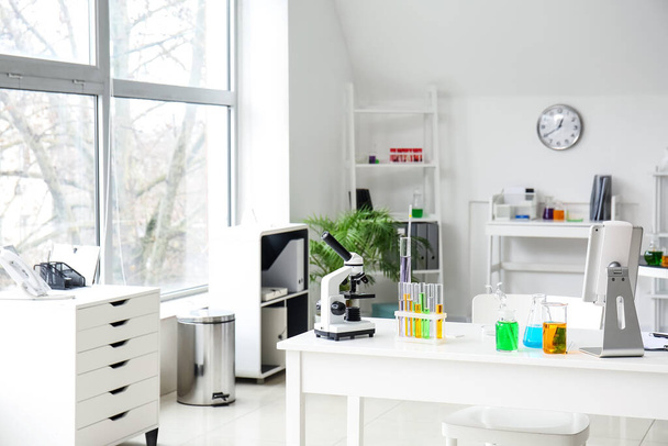 Mikroskop, tablet i szkło chemiczne na stole w laboratorium medycznym - Zdjęcie, obraz