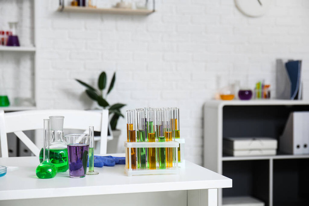 Verschillende chemische glaswerk met monsters op tafel in medisch laboratorium - Foto, afbeelding