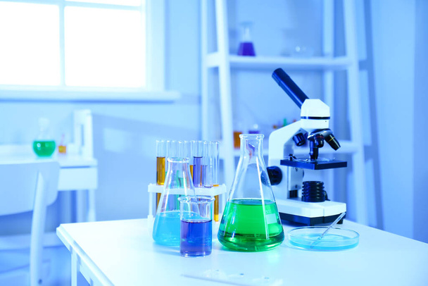 Artículos de vidrio químico con muestras en la mesa en el laboratorio médico - Foto, Imagen