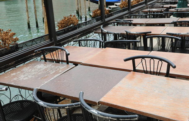 tyhjät pöydät ja tuolit suljetussa ulfresco-ravintolassa ilman ihmisiä koronaviruksen aiheuttaman kauhean lukituksen aikana Venetsiassa Italiassa Euroopassa - Valokuva, kuva