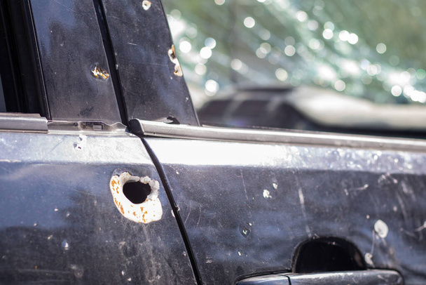 Coche lleno de balas. Guerra de Rusia contra Ucrania. Un coche de civiles baleado por el ejército ruso durante la evacuación de mujeres y niños. Rastros de balas y fragmentos de proyectiles - Foto, Imagen
