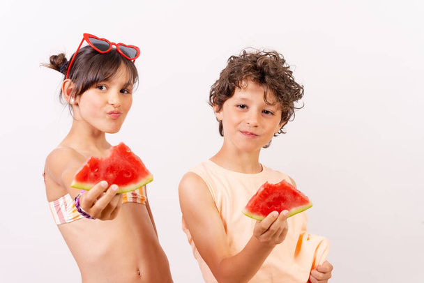 Children eating a watermelon in the summer heat, school vacation concept. White background - Фото, зображення
