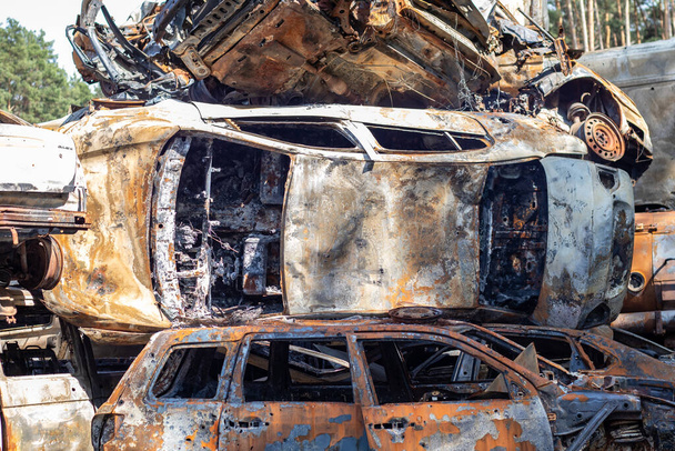 Sok rozsdás égett autó volt Irpenben, miután az orosz hadsereg lelőtte őket. Oroszország háborúja Ukrajna ellen. A háborús övezetből evakuálni próbált civilek lerombolt autóinak temetője - Fotó, kép