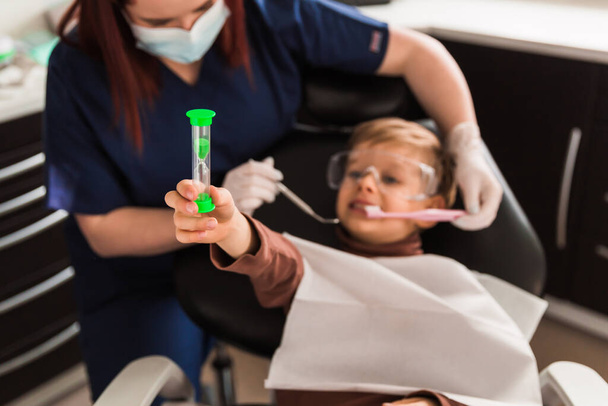 Smiling little boy in dentists chair, being educated about prope - Fotografie, Obrázek