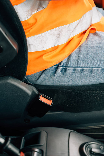 Close up of woman hand buckle the car safety belt. Truck driver occupation . High quality photo - Foto, afbeelding