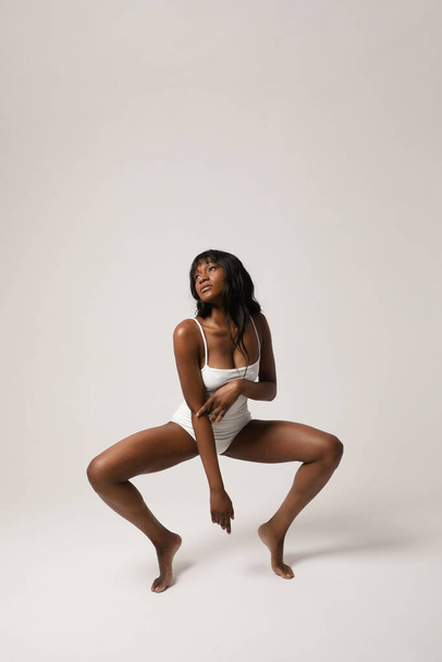 Young African woman with perfect body posing indoor. Body and skin care. High quality photo. - Fotó, kép