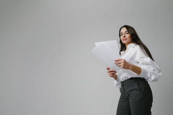 Middle-aged businesswoman, mentor coach standing over white wall holds documents. High quality photo. - Fotografie, Obrázek